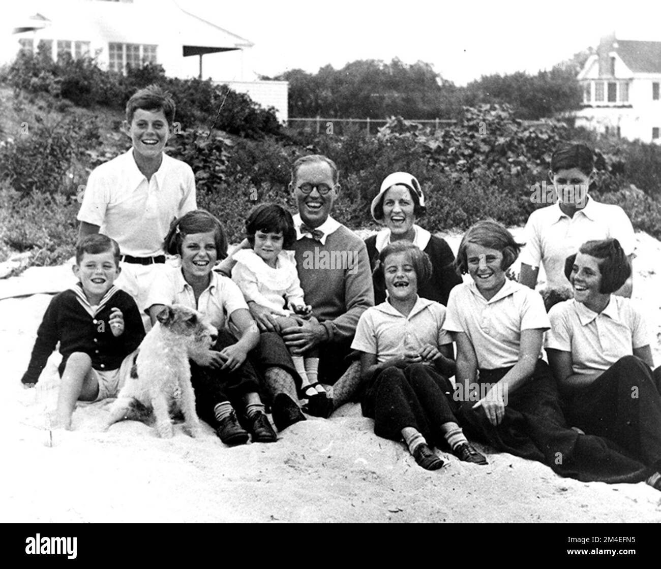 PC 8  The Kennedy Family at Hyannis Port, 1931. L-R: Robert Kennedy, John F. Kennedy, Eunice Kennedy, Jean Kennedy (on lap of) Joseph P. Kennedy Sr., Rose Fitzgerald Kennedy (behind) Patricia Kennedy, Kathleen Kennedy, Joseph P. Kennedy Jr. (behind) Rosemary Kennedy. Dog in foreground is 'Buddy'. John F Kennedy was 14 years old when this photo was taken Stock Photo