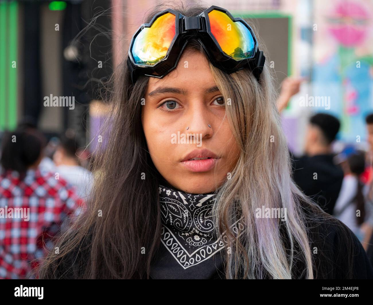Medellin, Antioquia, Colombia - November 14 2022: Portrait of a Young Colombian Woman with Heterochromia Wears Colored Glasses in the Shape of a Heart Stock Photo