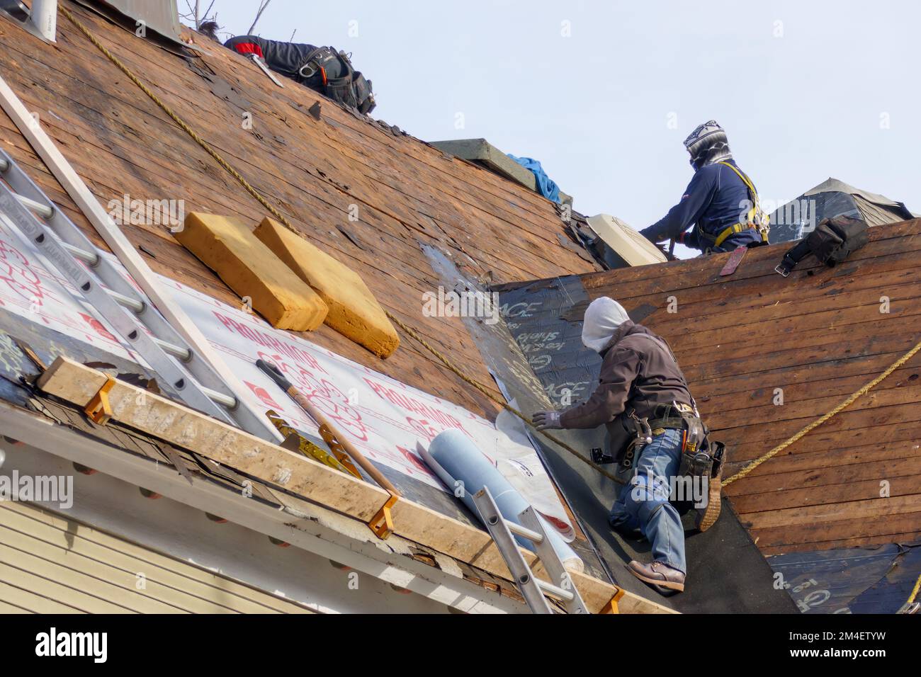 Workers replacing roof on Victorian house. Historic District, Oak Park, Illinois. Stock Photo