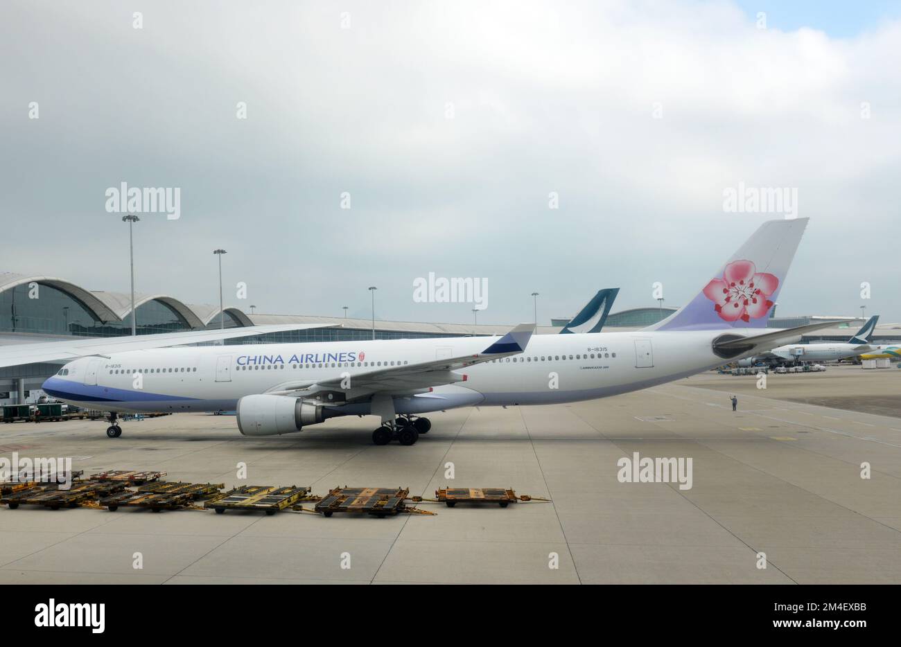An aircraft marshaller guiding a china airlines aircraft at the hk