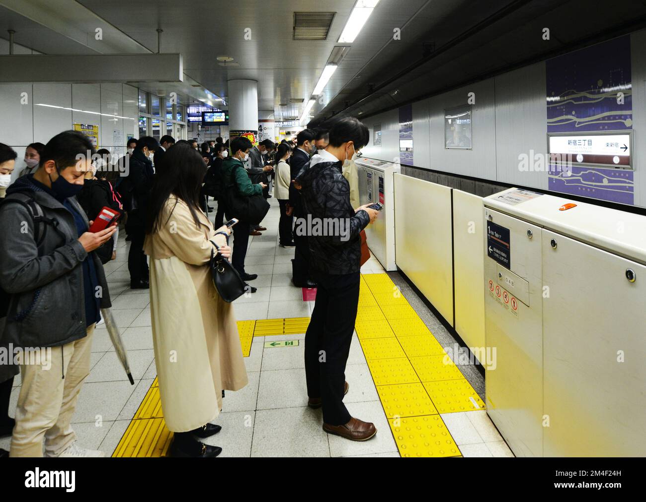 Japanese passengers waiting to board the Metro train in Tokyo, Japan