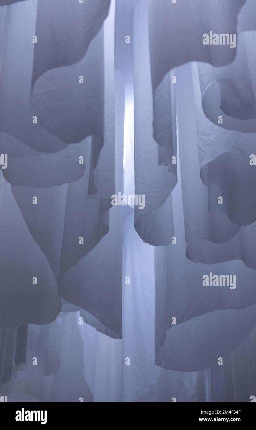 A vertical shot of a gray hanging billowy fabric creating dreamy enchanting texture - wallpaper Stock Photo