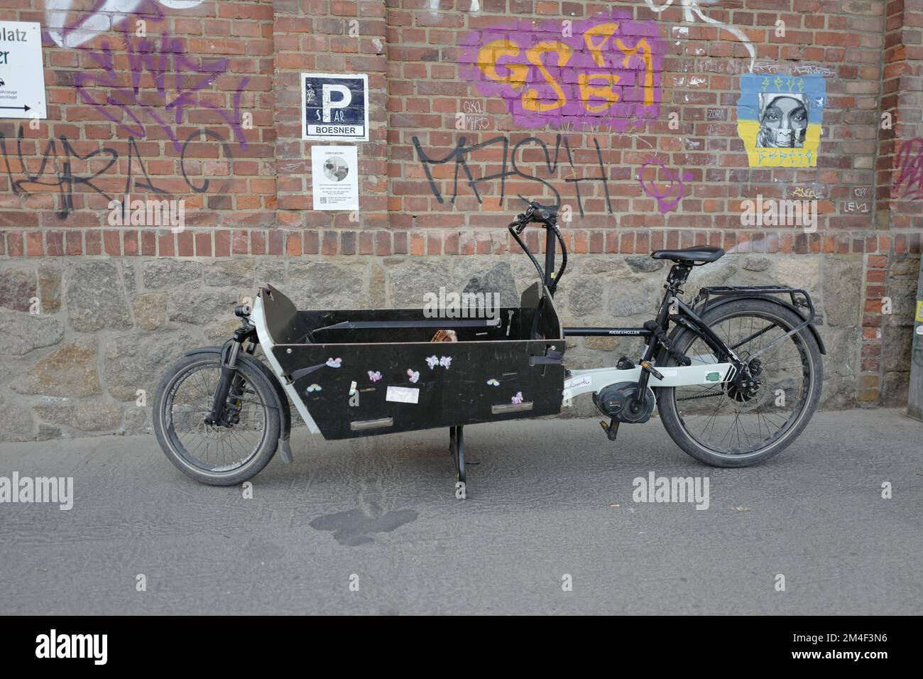 Cargo bicycle in front of a wall with graffiti Stock Photo