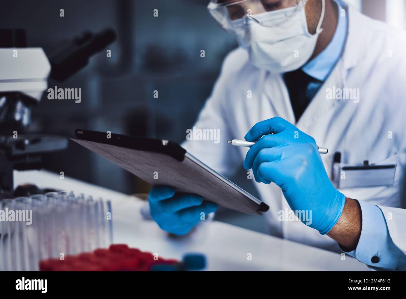 Ordering new lab equipment online. an unrecognizable male scientist working in a lab. Stock Photo