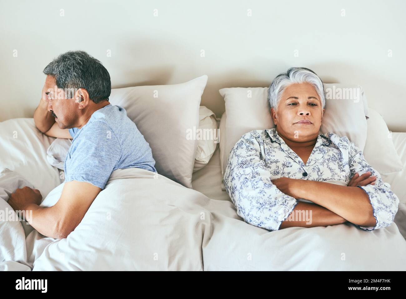 What did I do wrong now. an irritated looking mature couple lying in