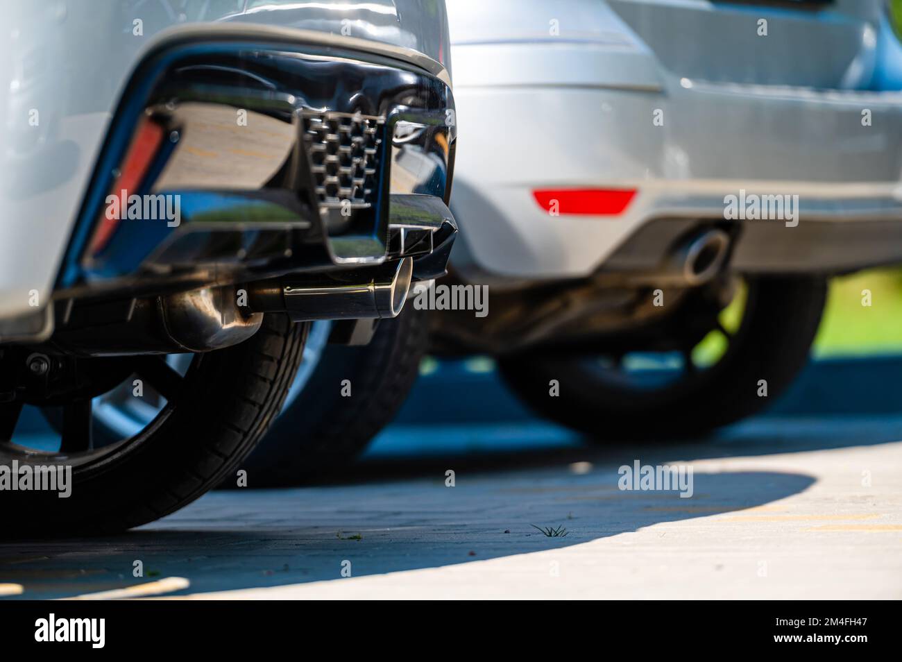 close-up of the wheels and bumpers of a car parked in the yard of a residential house, lower section Stock Photo