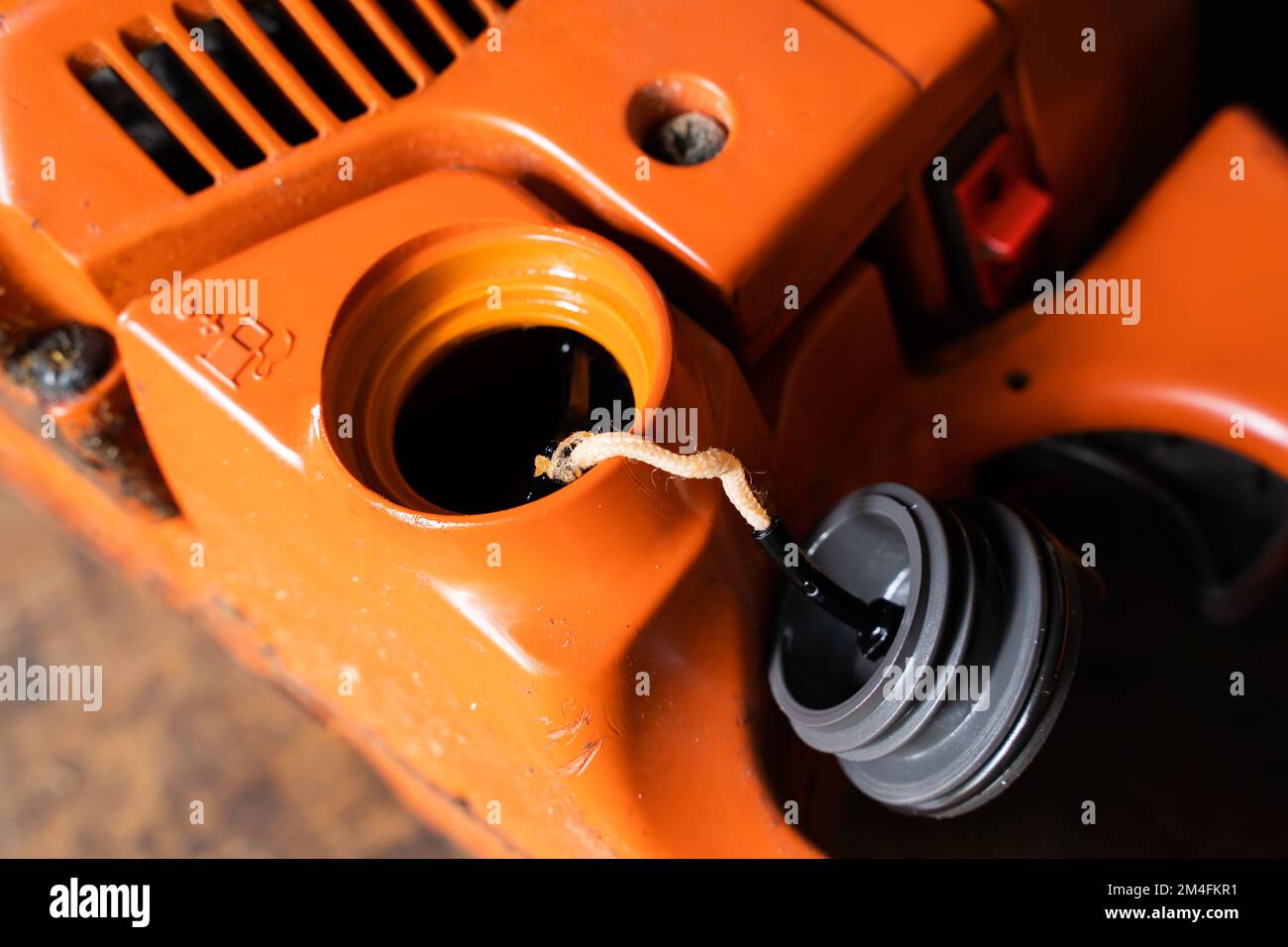 Open filler neck for the fueloil mixture in the chainsaw. Filling the