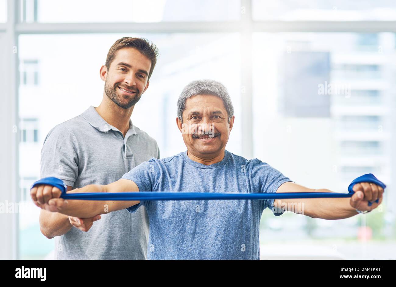 Im getting better one stretch at a time. Cropped portrait of a young male physiotherapist assisting a senior patient in recovery. Stock Photo