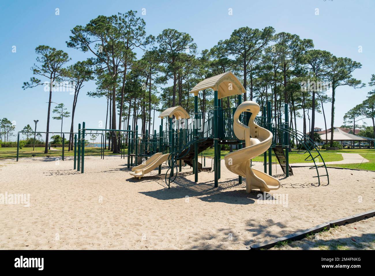 https://c8.alamy.com/comp/2M4FNKG/destin-florida-playground-on-a-sand-with-slides-monkey-bars-and-swings-playground-near-the-tall-trees-and-grass-land-field-at-the-background-2M4FNKG.jpg