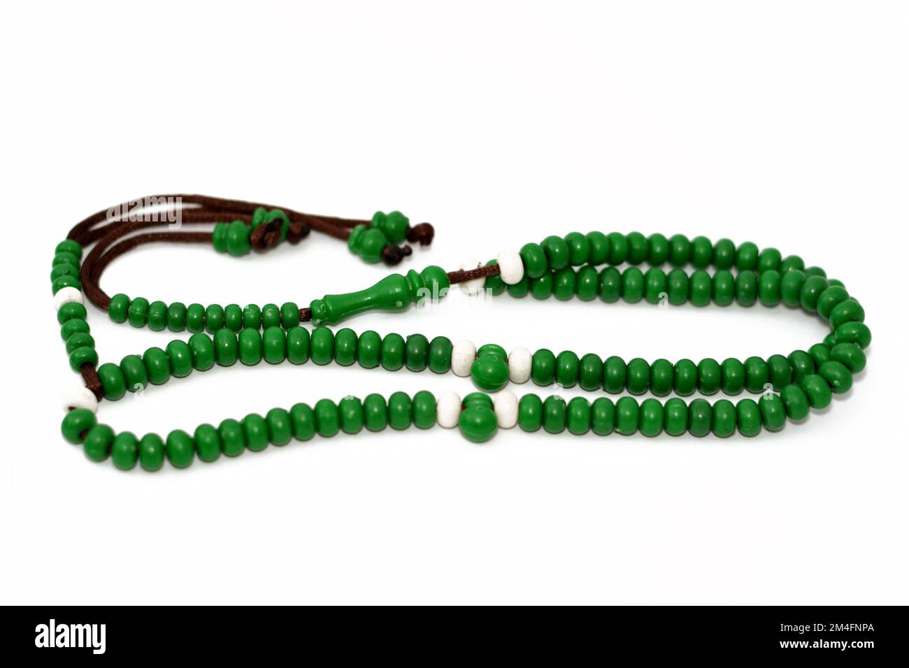 Islamic rosary in green color with 99 rosary beads that Muslims use it to give praise to Allah using sentences to mention God like Praise and glory to Stock Photo