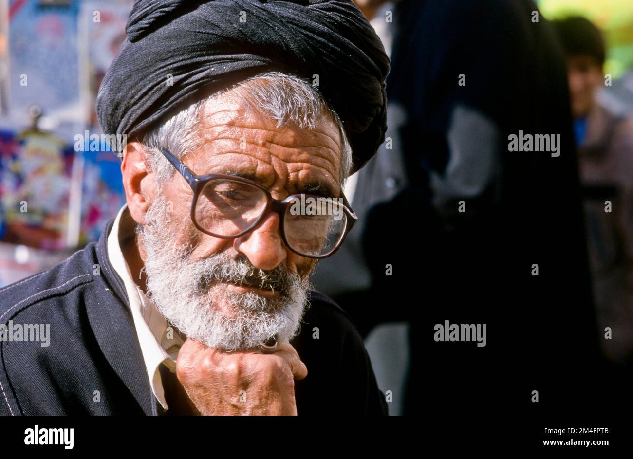 Man with glasses in the bazar of Shiraz, thinking. Stock Photo