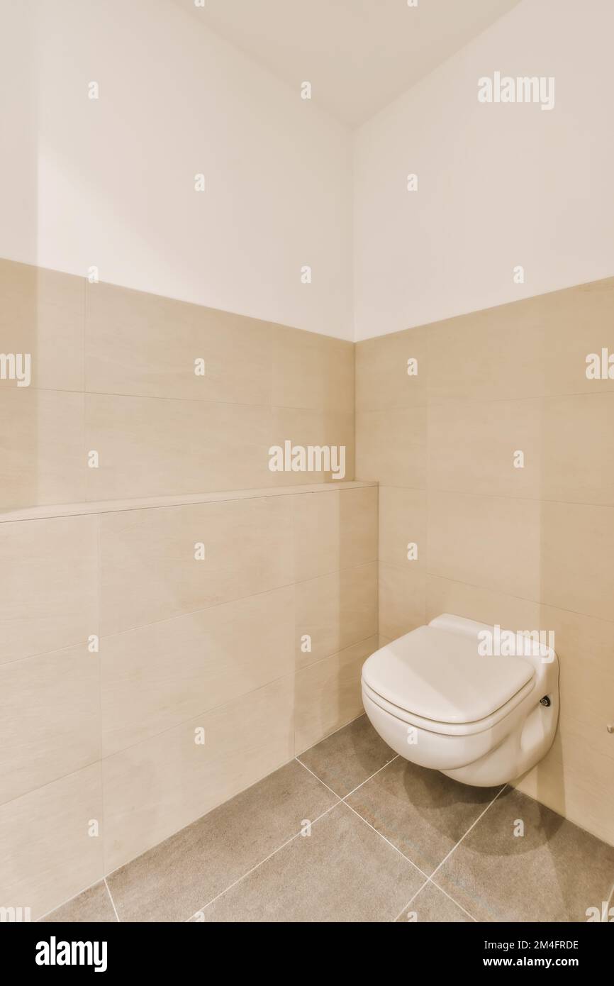 a white toilet in the corner of a bathroom with beige tiles on the