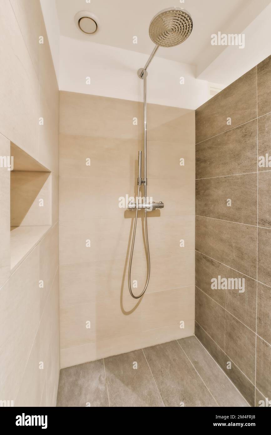 a shower in a bathroom with tiled walls and tile flooring on the wall
