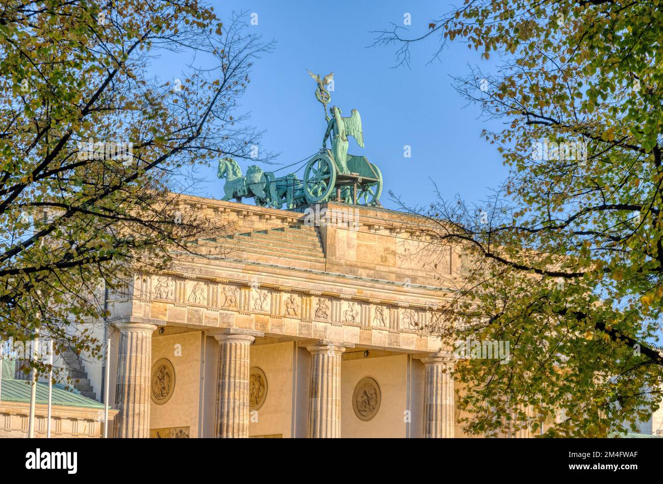 The backside of the famous Brandenburg Gate in Berlin seen through some trees Stock Photo