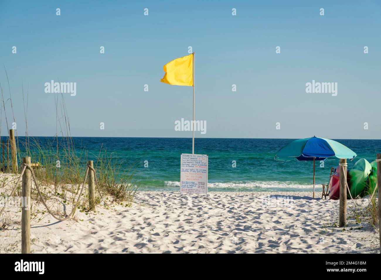 Yellow flag on a pole at the center in a beach at Destin, Florida