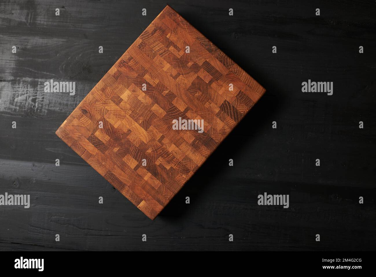 Empty wood cutting board on black background. Stock Photo