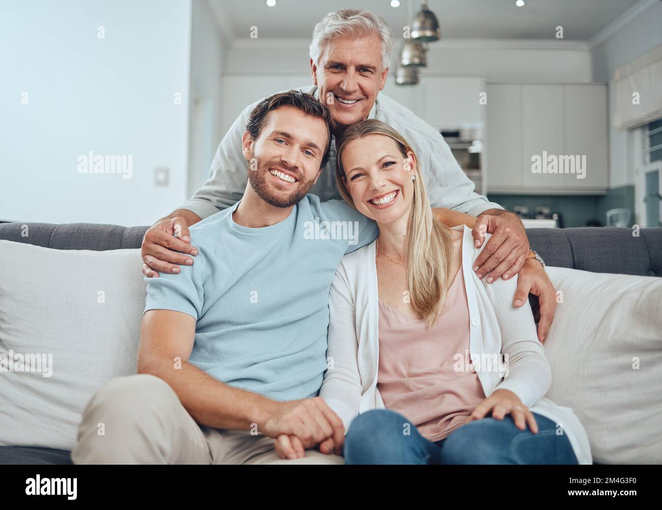 Portrait, family and relax on sofa in living room, smiling and bonding. Love, care and grandfather, man and woman embrace on couch in lounge, having Stock Photo