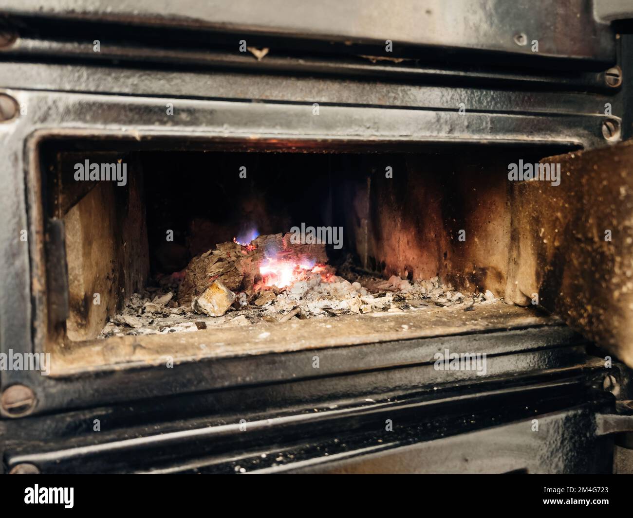 Fire in metal stove - macro close-up inside a Bavarian Kachelofen, Bavaria, Germany, Europe Stock Photo