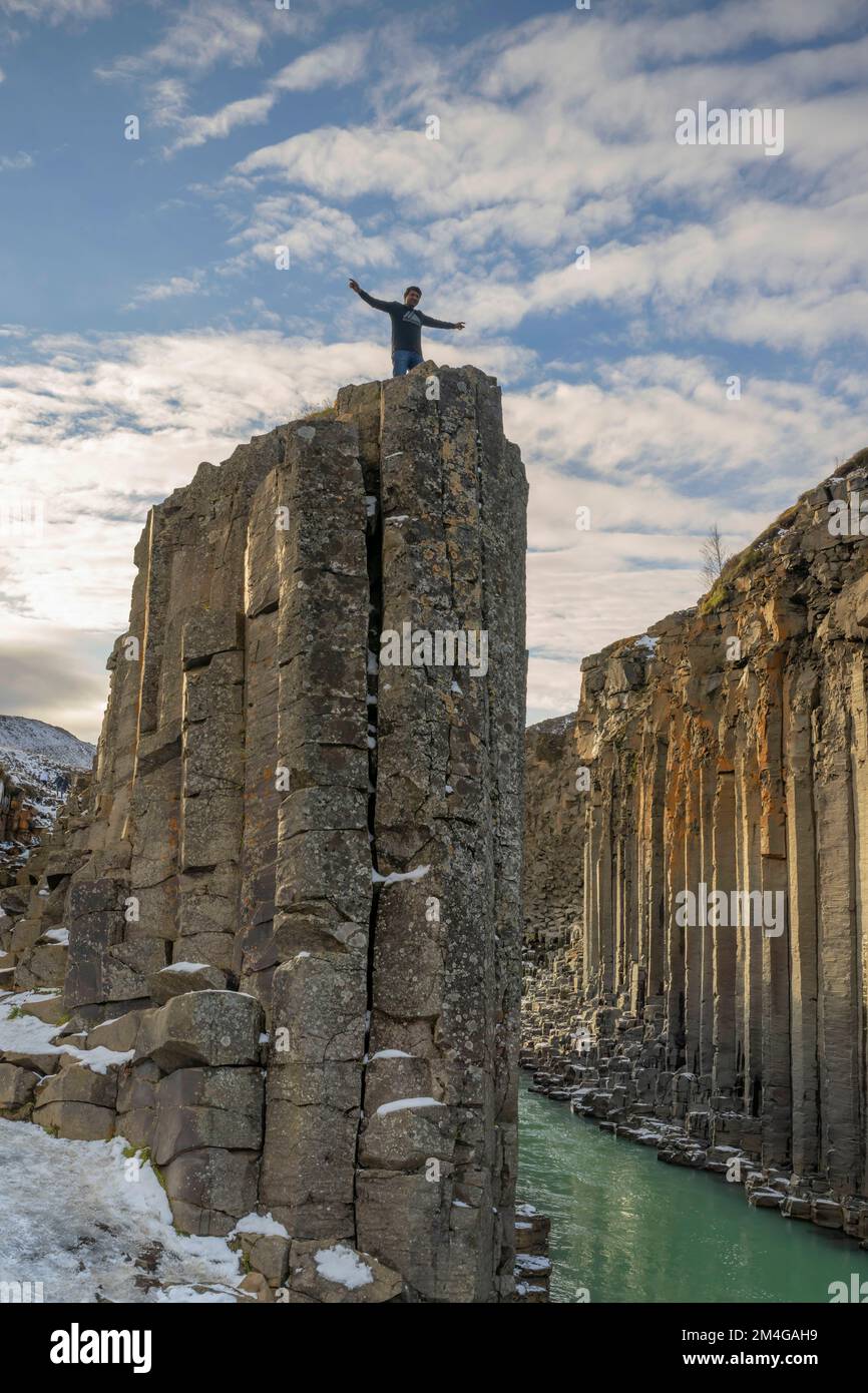 man standing on basalt pillars of the Studlagil canyon, Iceland, Joekuldalur Stock Photo