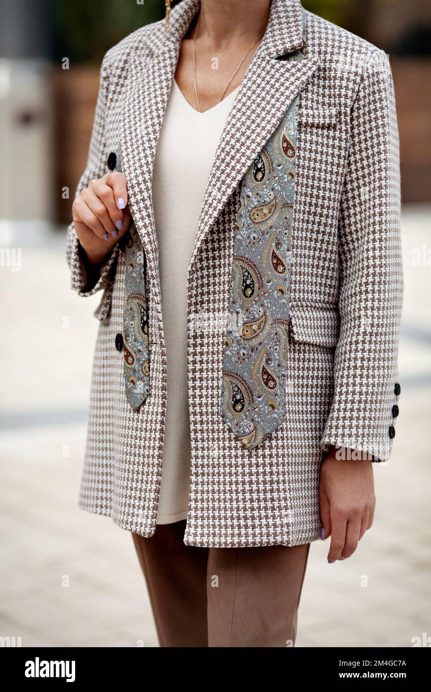 Woman in fashionable clothes oversize double breasted jacket houndstooth color and tie. Street style fashion Stock Photo
