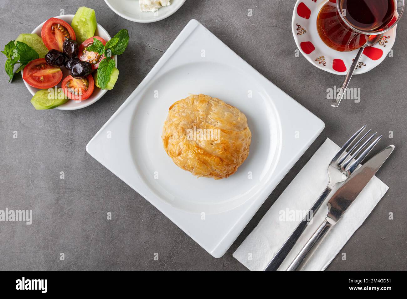 Izmir boyoz on a white porcelain plate on a stone table Stock Photo