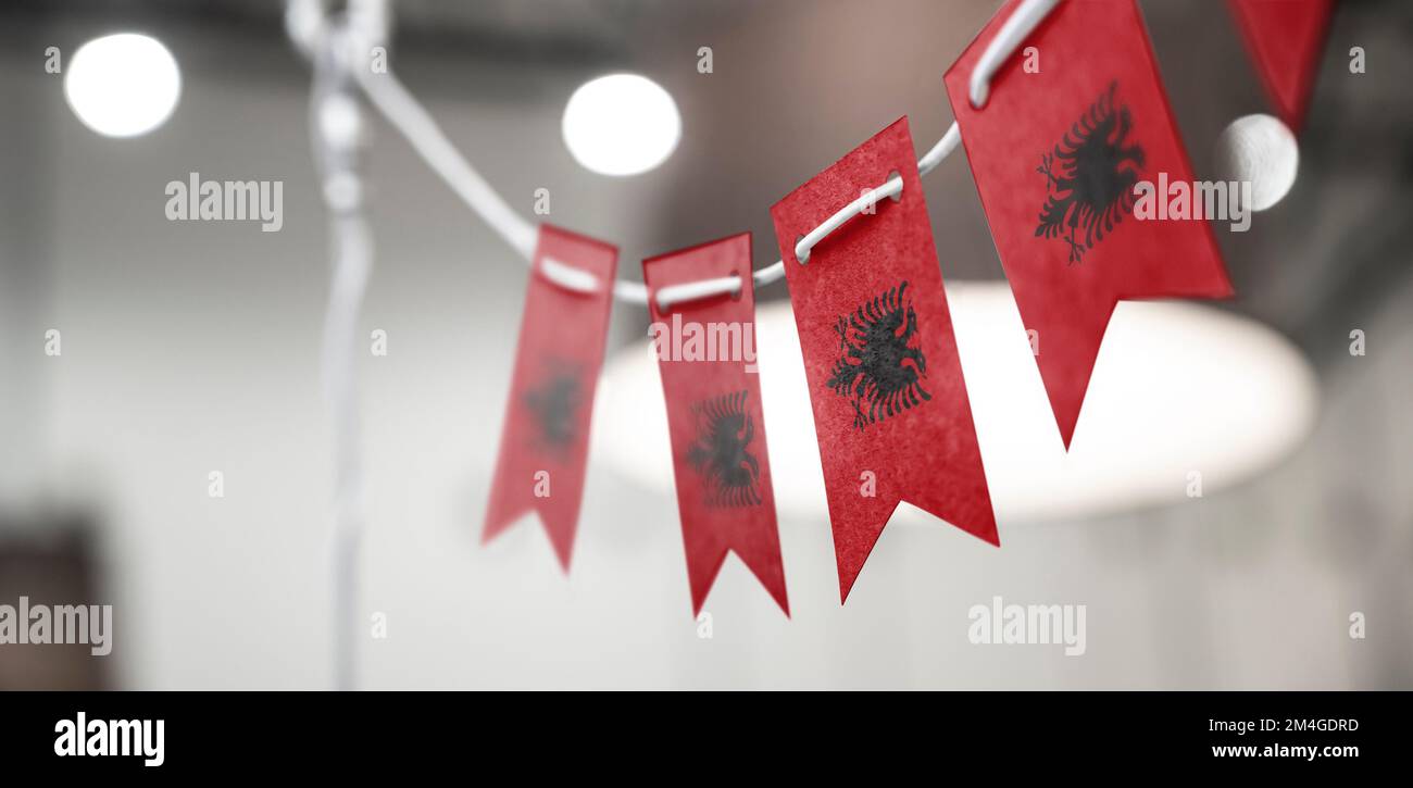 A garland of Albania national flags on an abstract blurred background. Stock Photo