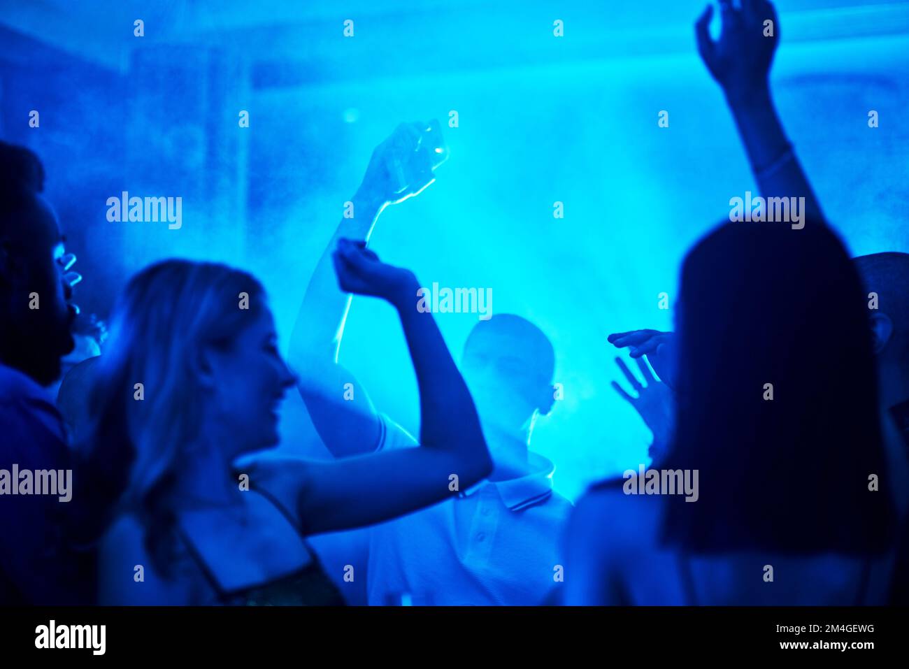 People dancing in a nightclub, crowd at a party listening to disco or social celebration of new years eve in Las Vegas. Music festival event Stock Photo
