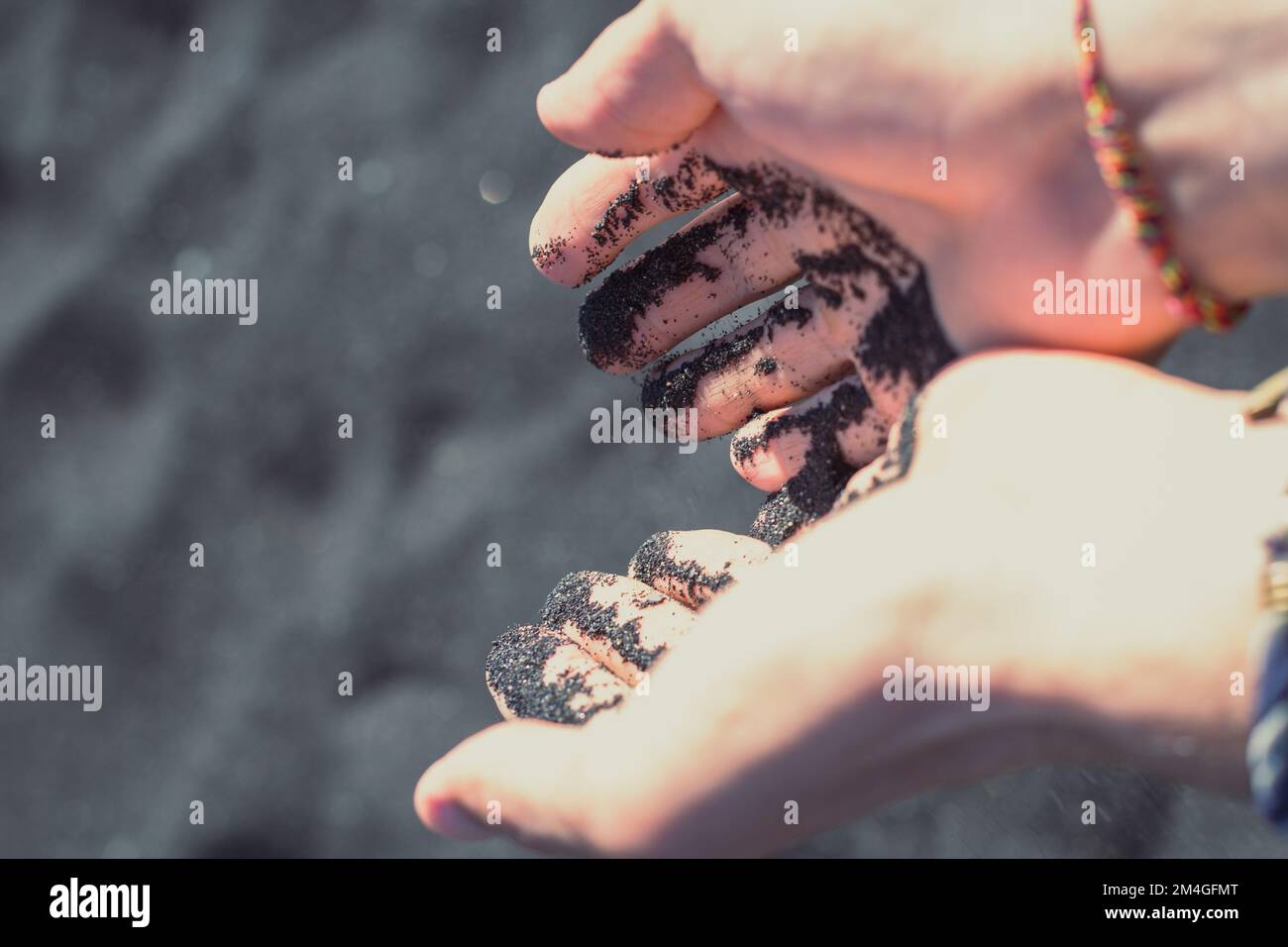 Close up male palms with black sand concept photo Stock Photo