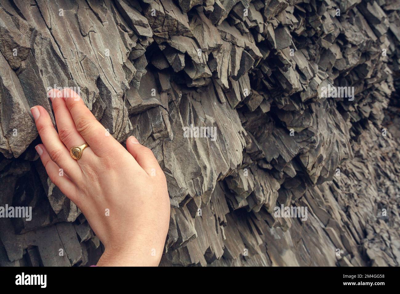 Close up woman touching basalt rock concept photo Stock Photo