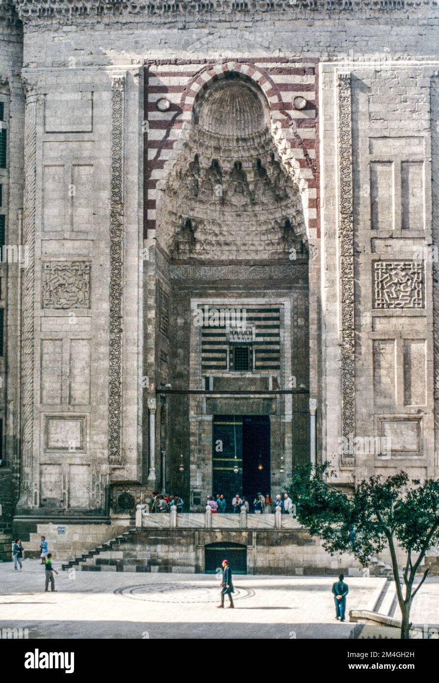 The main entrance portal to the Sultan Hassan mosque with Muqarnas (stalactite-shaped decoration) in Cairo, Egypt. Archival scan from a slide. February 1987. Stock Photo