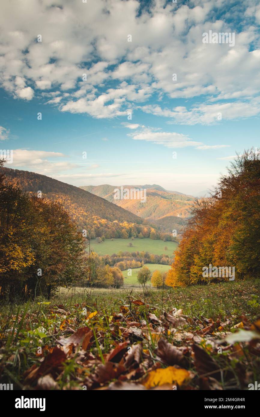 Fairy-tale autumn landscape with colourful leaves and a view of the valley and a blue sky with white clouds. Mojtin, Strazov mountains, Slovakia. Stock Photo
