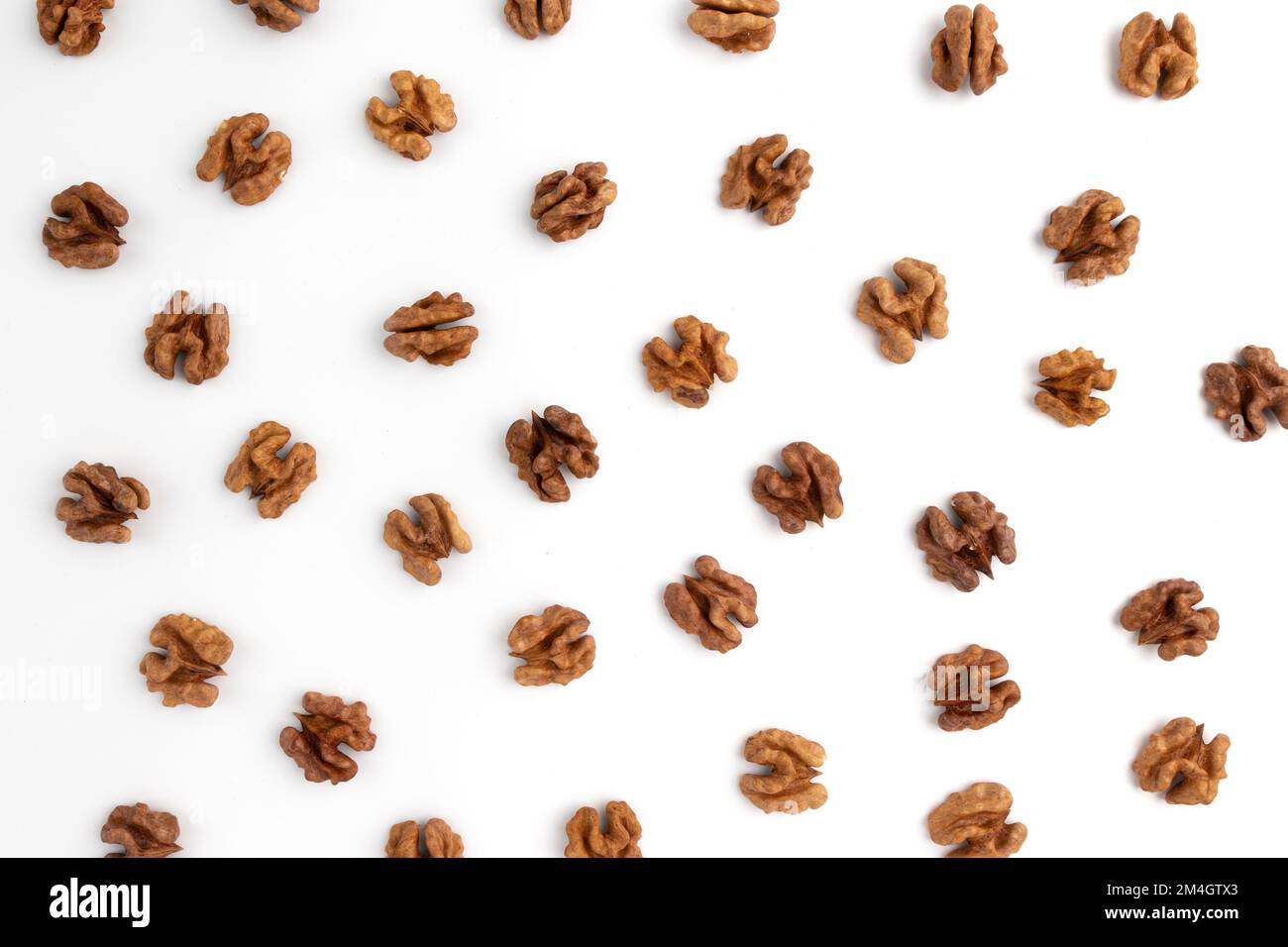 halves of walnuts isolated on white background, pattern top view, snack food concept, vegan meal Stock Photo