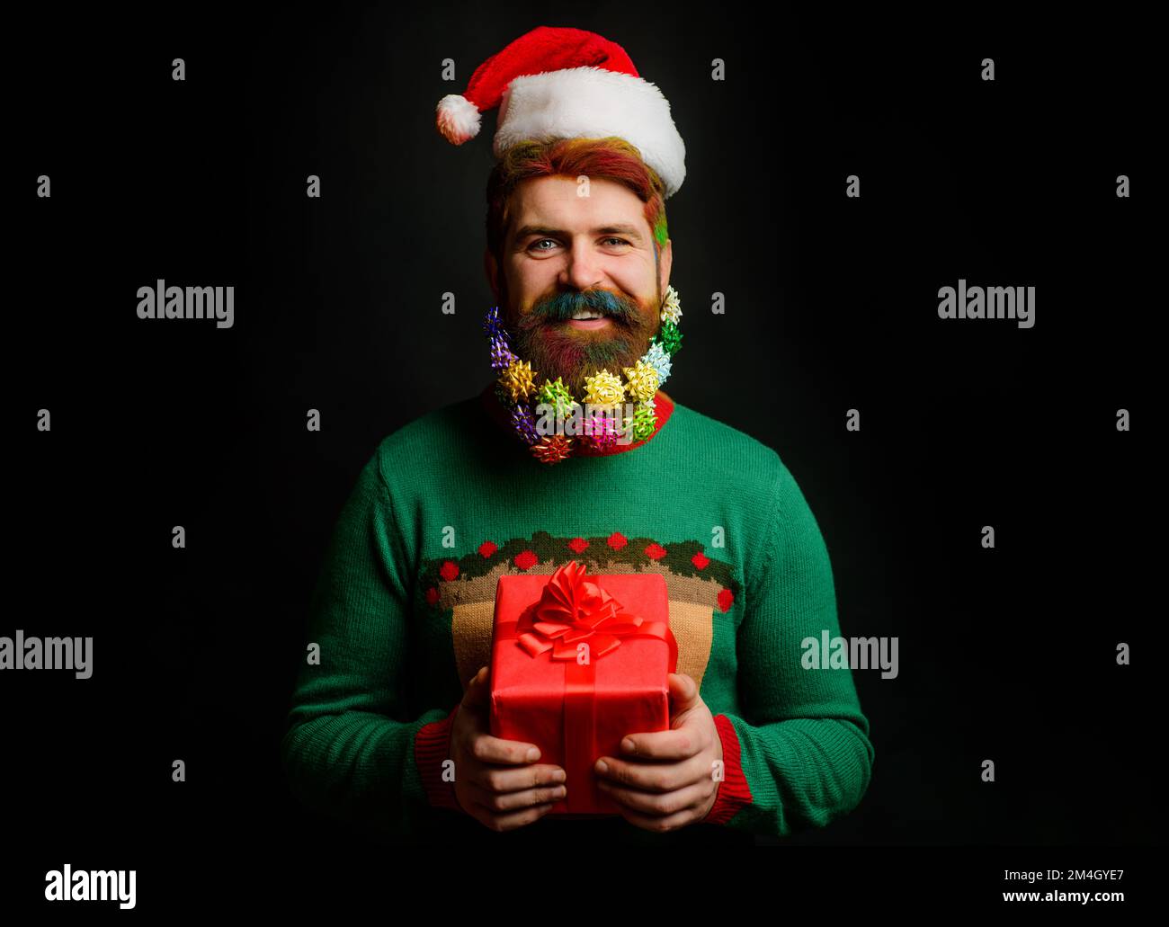 Bearded man in Santa hat with present gift box. Merry Christmas and happy New year Stock Photo