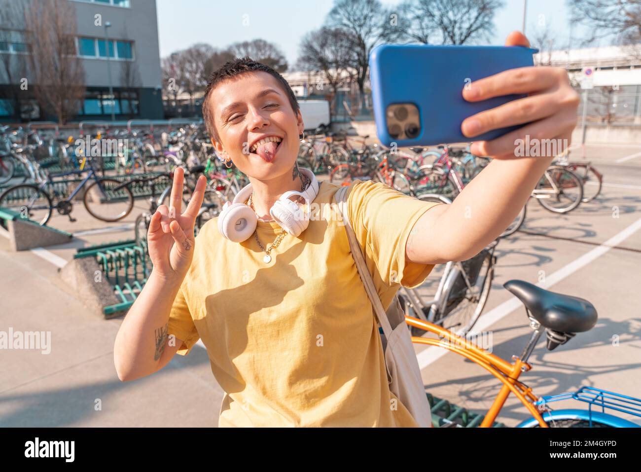 Woman takes a selfie with cellphone in a bicycle parking Stock Photo