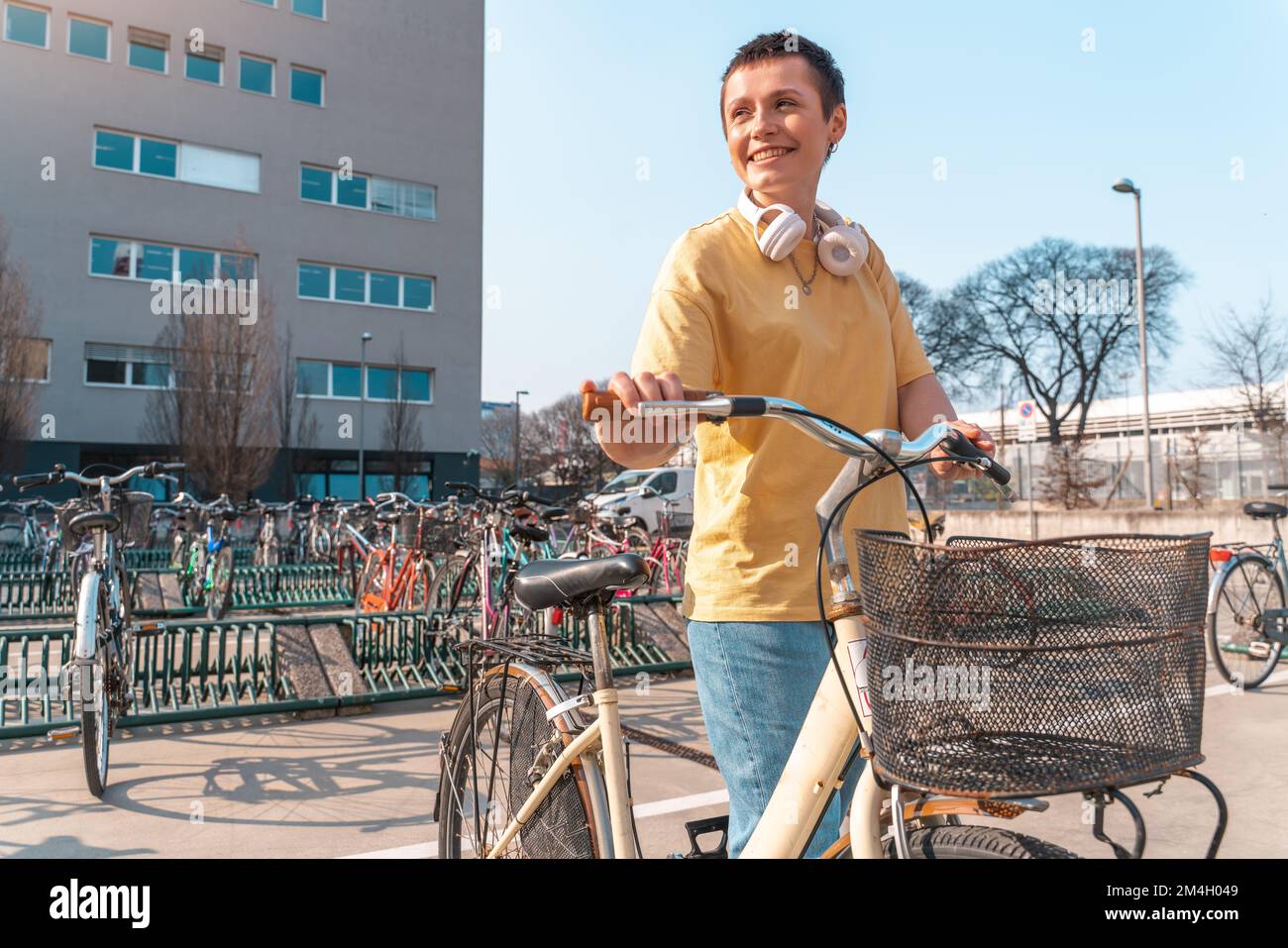 Woman takes a rented bicycle in a bicycle parking Stock Photo