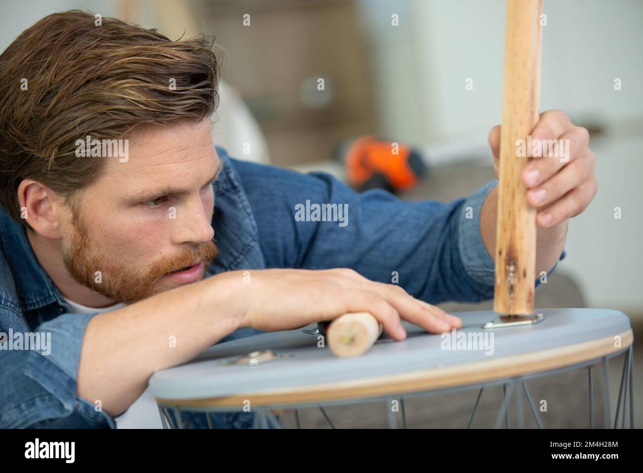 concentrated man in fixing a chair Stock Photo Alamy