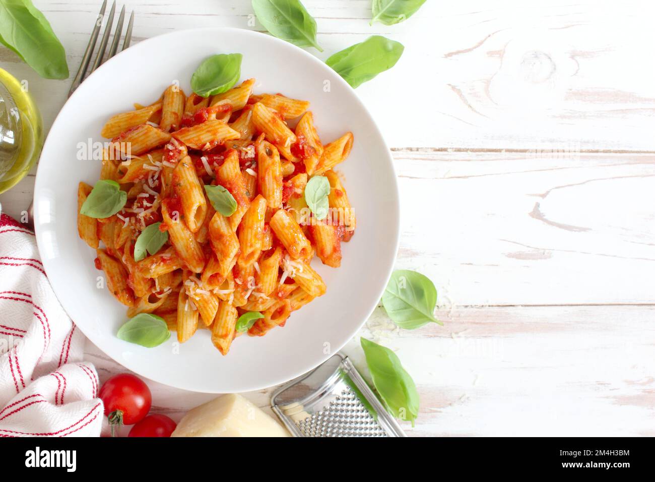 Penne pasta with tomato sauce, parmesan cheese and basil. Top view with