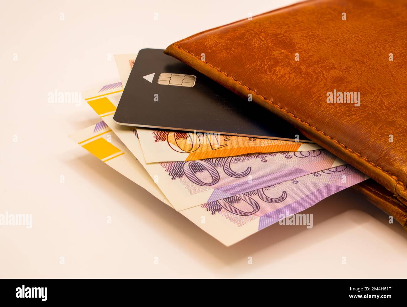 close-up of a light brown tan leather wallet containing bank cards, ten and twenty pound notes Stock Photo