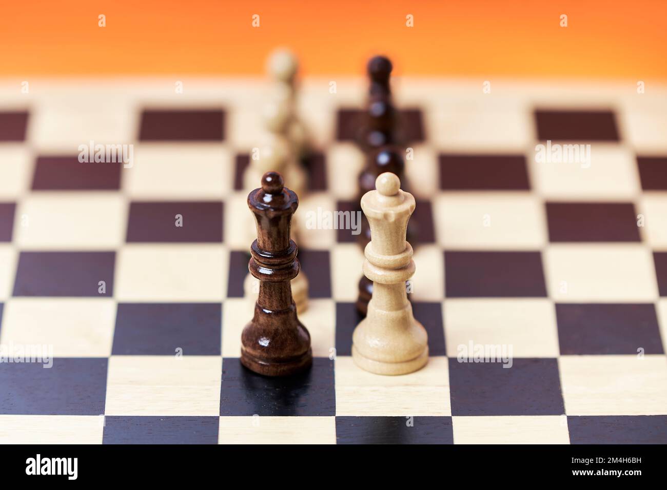 Chess pieces on a chessboard on an orange background. Business strategy chess move Stock Photo
