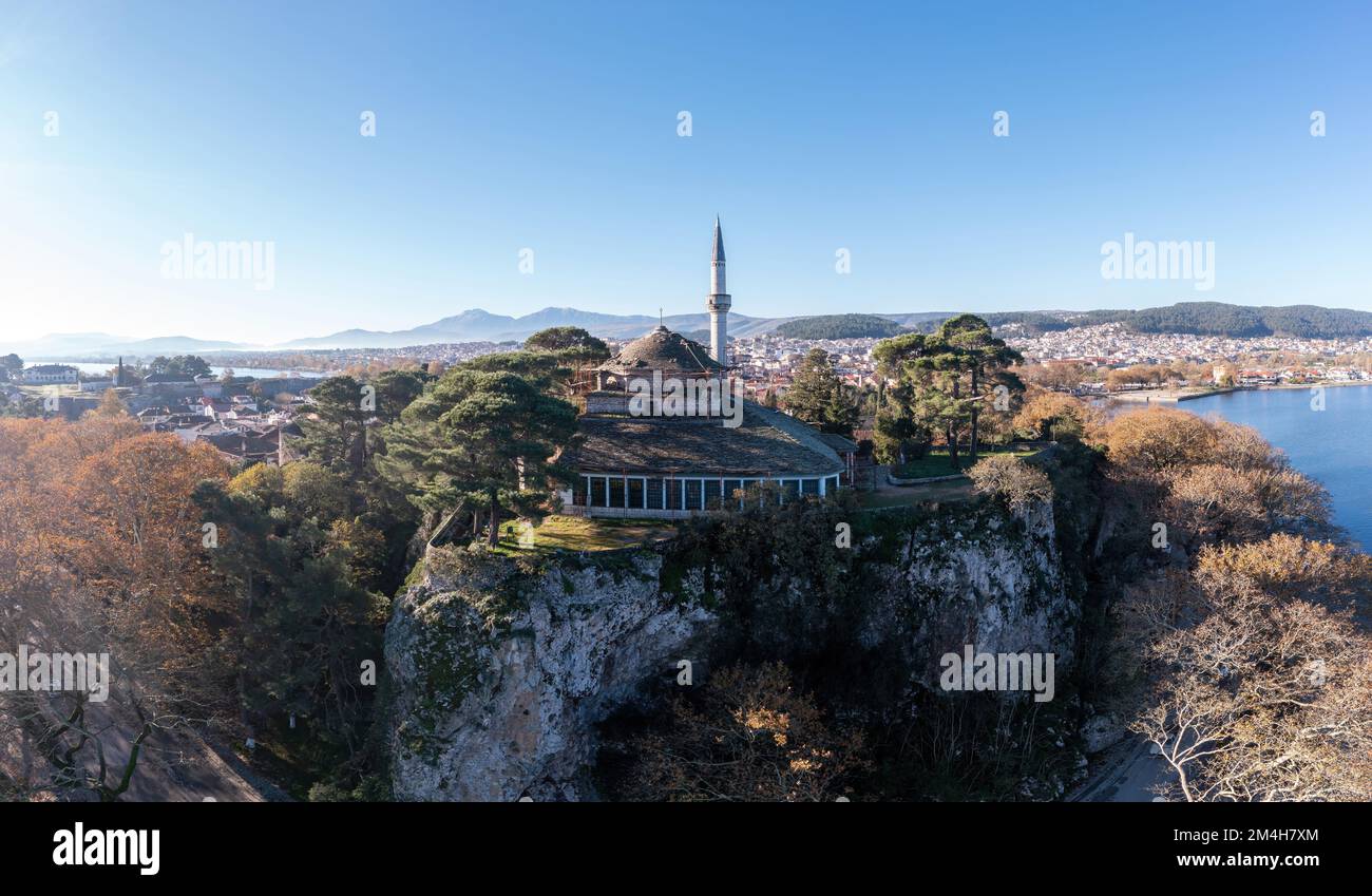 Greece, Ioannina Pamvotida Lake, Epirus. Aerial drone view of Giannena city and Aslan Pasha mosque on top of rocky hill, blue sky background. Stock Photo