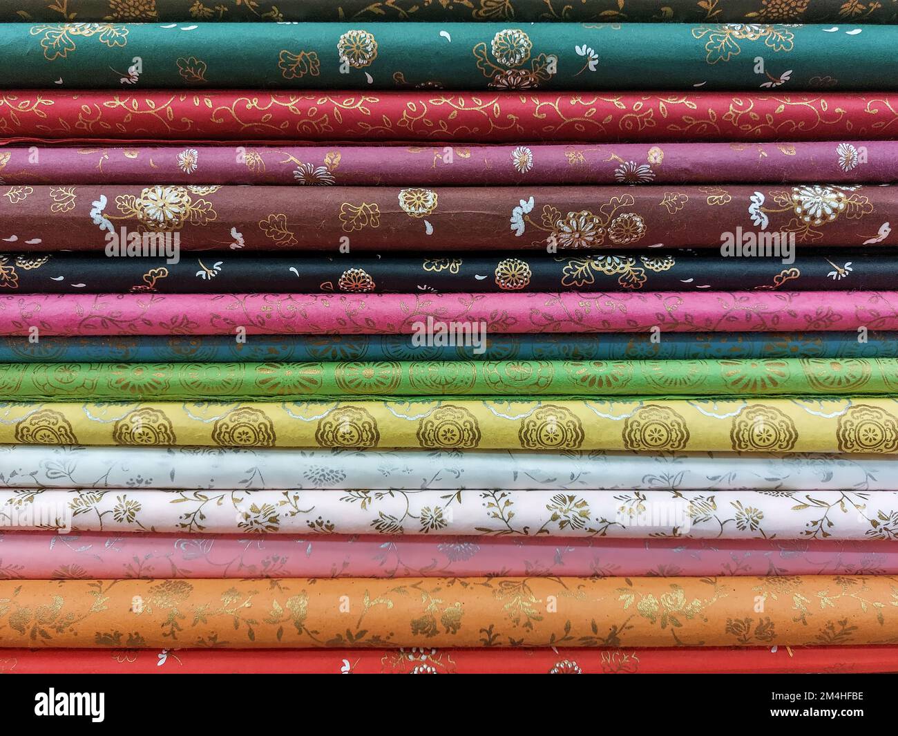 Floral fabrics and other patterns They are folded and stacked in layers and come in a variety of colors, creating a colorful image. Stock Photo