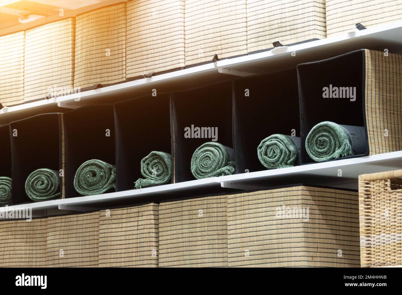 Green towels in square wicker baskets on store shelves Stock Photo
