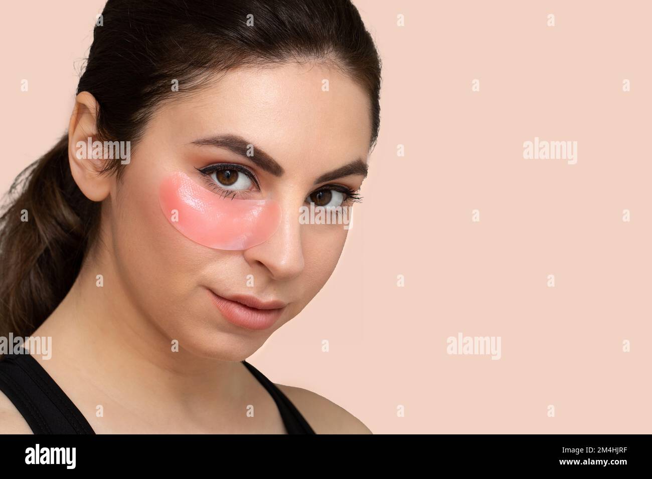 Young girl with a patch applied under her eyes to reduce dark circles and bags under her eyes
