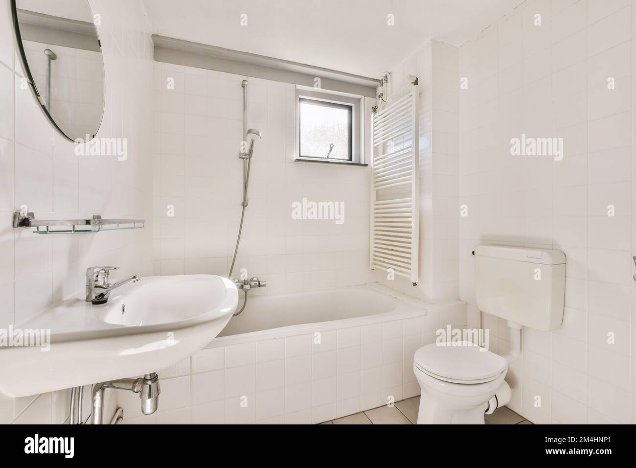 a bathroom with a sink, toilet and bathtub in the same room on the other side of the wall Stock Photo