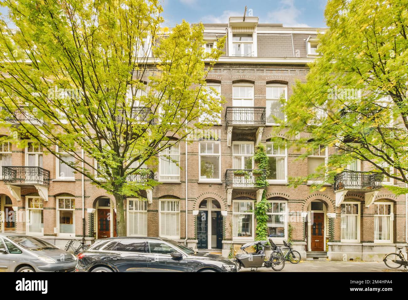 an apartment complex in amsterdam, the netherlands with cars parked on ...