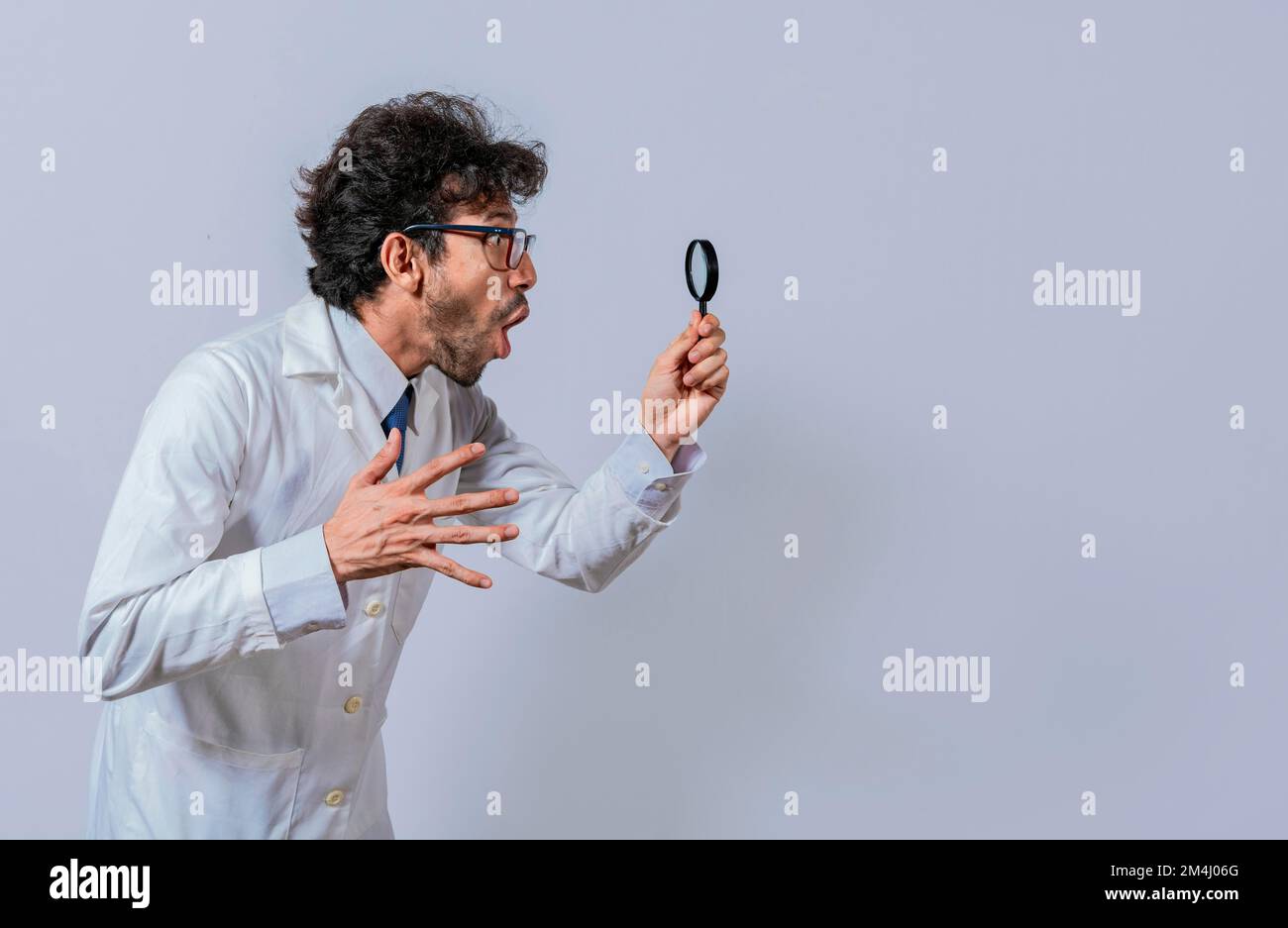 Scientist holding a magnifying glass looking to the side, Man in a ...