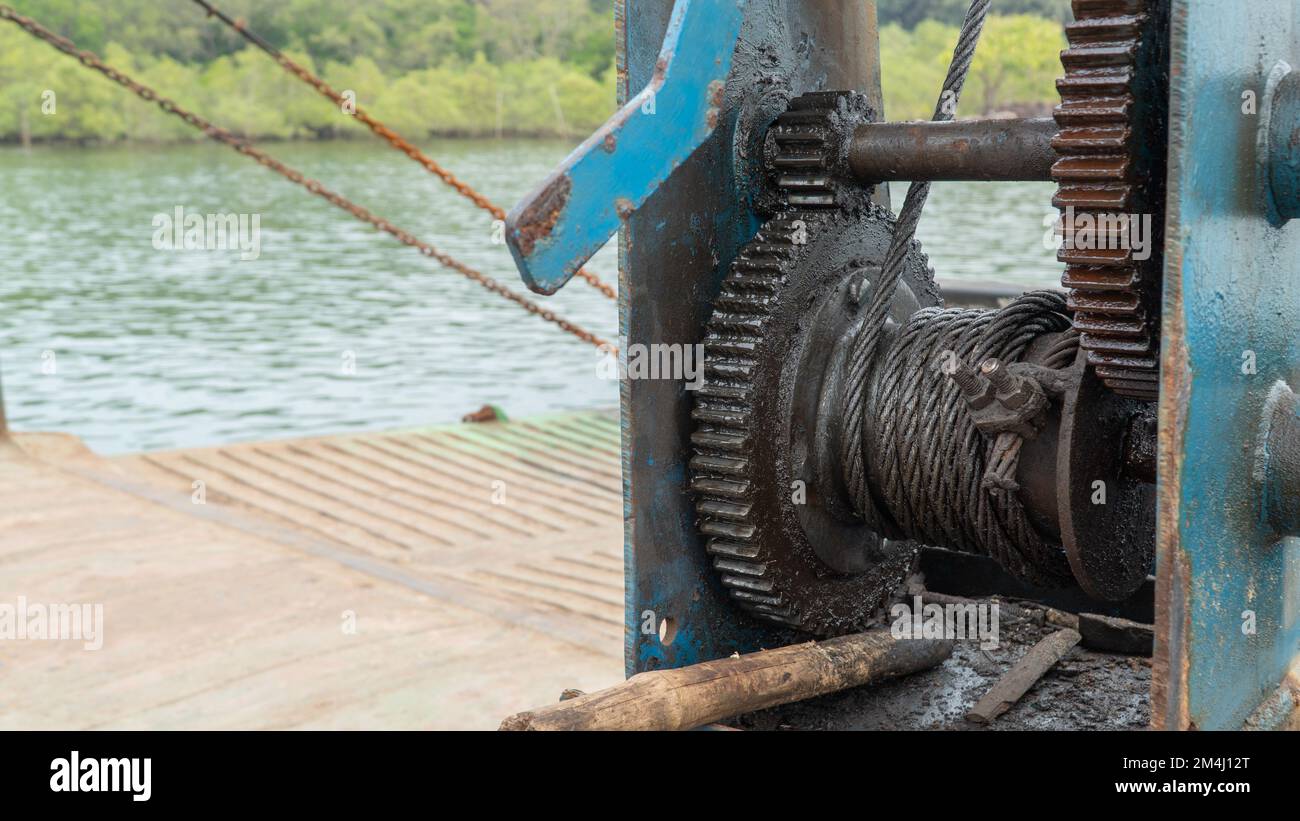The mechanism pulls a metal cable onto a gear wheel Stock Photo