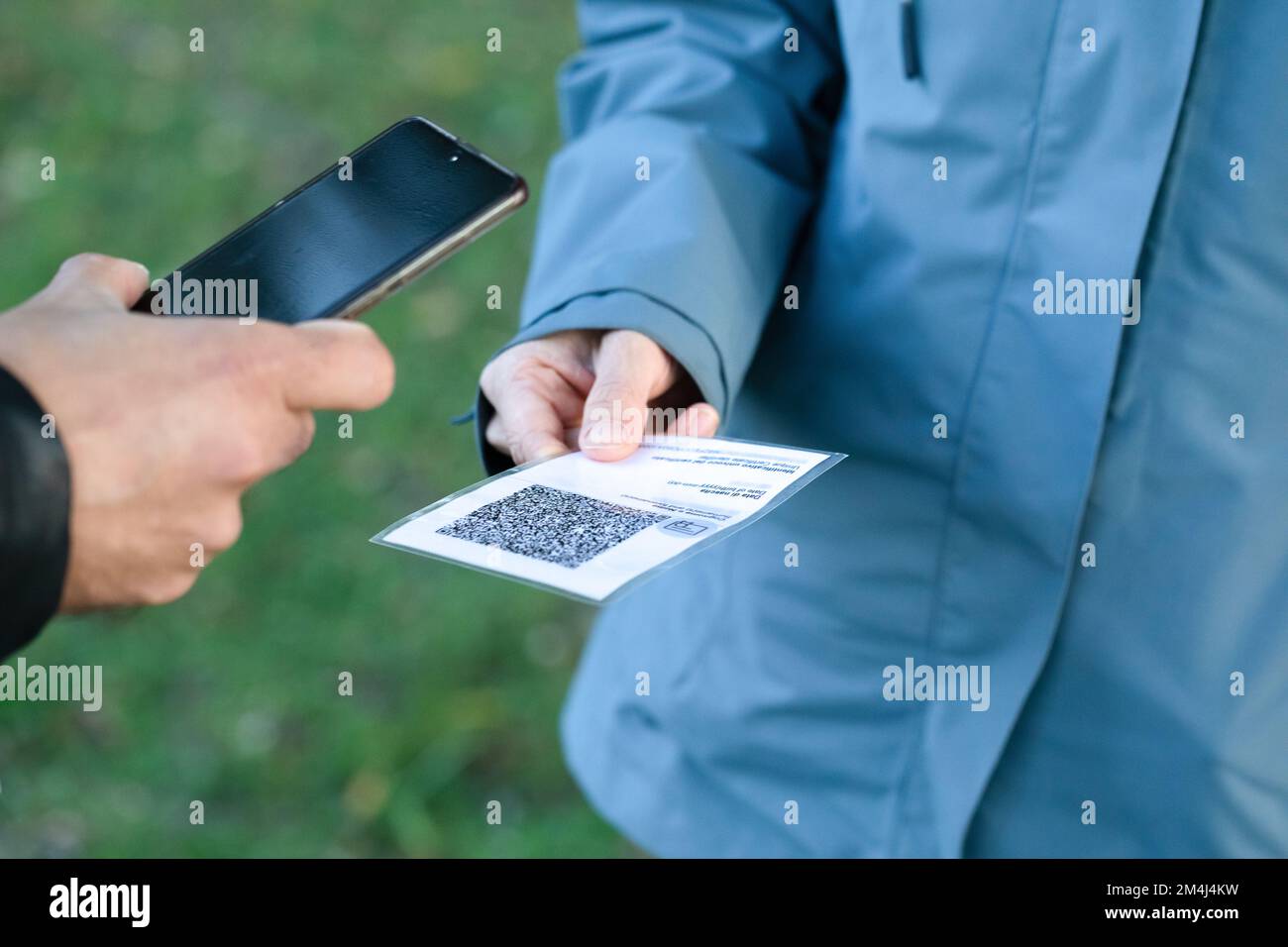 close-up of hands while checking the green passport with smartphone application. Concept of safety and prevention against covid-19 Stock Photo