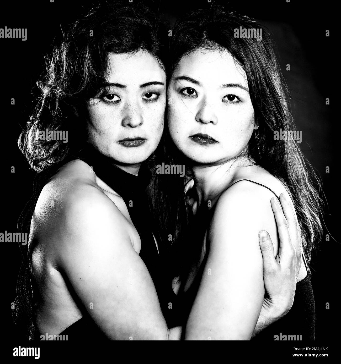 Two Asian woman, sisters, Korean siblings, embracing, black and white shot Stock Photo