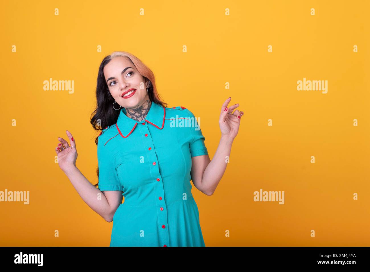 Beautiful woman posing to the camera over yellow background. Studio Shot Stock Photo